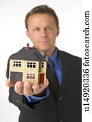 Businessman Holding Small House 