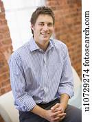 Businessman sitting in office space smiling