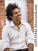 Businessman sitting in office space smiling