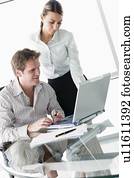 Two businesspeople in boardroom with laptop