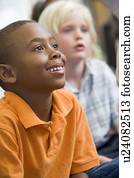 Students in class sitting on floor paying attention (selective focus)