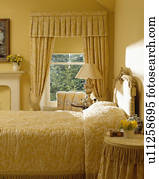 Patterned yellow wallpaper and matching curtains behind ...