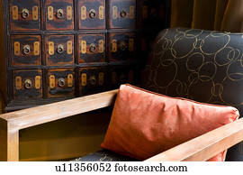 Detail of contemporary armchair and orange pillow