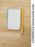 Pencil beside open spiral bound notepad Pencil beside open spiral bound notepad