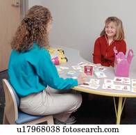 Cute young girl with a disability with her therapist during a speech therapy session. Cute young girl with a disability with her therapist during a speech therapy session.