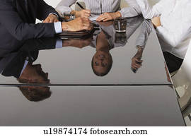Three business people's reflection in a table. Three business people's reflection in a table.