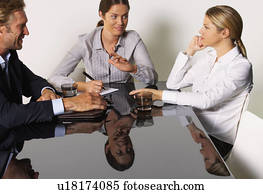 Three businesspeople at a table smiling.