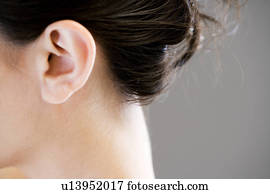 Ear and neck of a woman with dark hair up in a bun