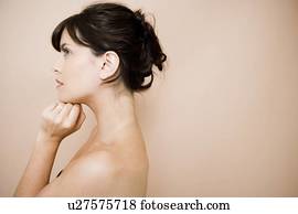 Side view of young woman with dark hair in a bun