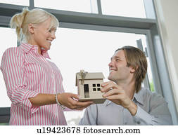 Couple holding a model of a house