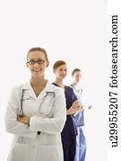 Portrait of smiling Caucasian medical healthcare workers in uniforms standing against white background.
