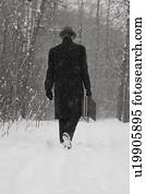 Man in dress coat walking through snow