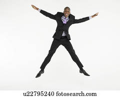 Man in suit jumping in star shape in studio