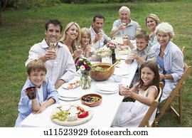 Portrait of three generation family dining in garden