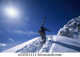 Skier hiking to mountain summit