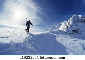 Skier hiking to mountain summit