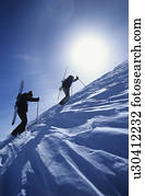 Skiers hiking to mountain summit