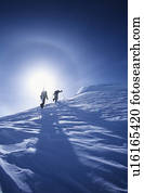 Skiers hiking to mountain summit