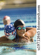 Female swimmer congratulating winner after race in pool