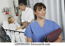 Portrait of female nurse in hospital room, patient in background Portrait of female nurse in hospital room, patient in background