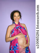 Portrait of expecting female with hands on stoomach.