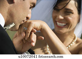 Caucasian prime adult male groom kissing hand of female bride. Caucasian prime adult male groom kissing hand of female bride.