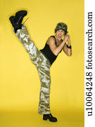 Hispanic mid-adult woman kicking.