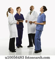 Full-length portrait of African-American man and Caucasian women medical healthcare workers in uniforms laughing standing against white background.