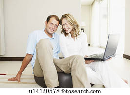 Happy couple at home with laptop Happy couple at home with laptop