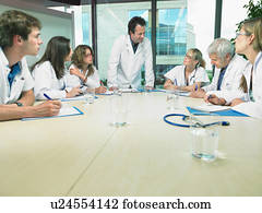 Business meeting of a group of doctors in a conference room around a table.
