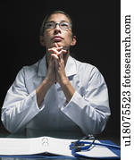 Close-up of female doctor thinking at her desk.