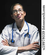 Portrait of smiling female doctor at her desk working late looking at camera. Portrait of smiling female doctor at her desk working late looking at camera.