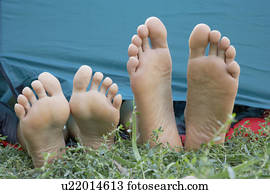 Two people's feet sticking out of tent door.