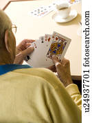 An elderly man playing cards