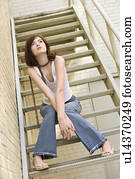 Woman sitting on fire escape.