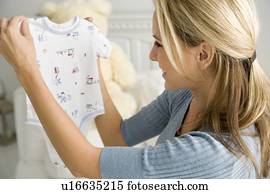 A mother holding a baby's vest