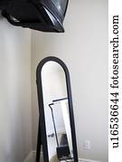 Full length mirror and television in corner of room