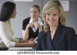 Businesswoman with co-workers in background