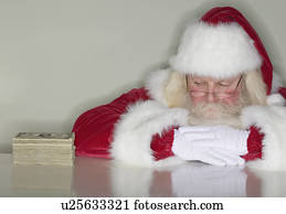 Santa Claus looking at stack of money