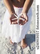 Girl on beach holding delicate starfish