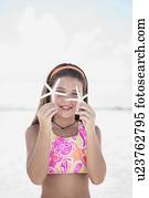 Girl on beach holding delicate starfish