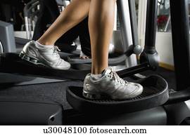 Woman exercising on elliptical machine