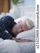 Senior man sleeping in bed