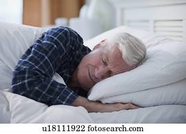 Senior man sleeping in bed
