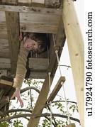 Boy reaching out from treehouse
