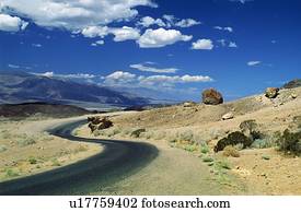 Death Valley, California, USA; Winding road in front of expansive desert
