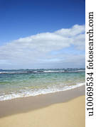 Landscape of waves lapping on beach.