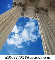 Low angle view looking up at blue sky with clouds and columns of Supreme Court building in Washington D.C.