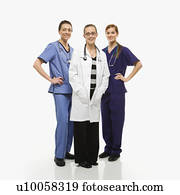 Portrait of smiling Caucasian women medical healthcare workers in uniforms standing against white background.