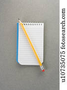 Pencil on top of open spiral bound notepad Pencil on top of open spiral bound notepad